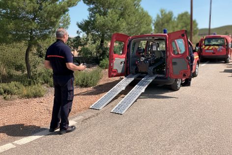 French firefighter loads Rhyno Protect into a light intervention vehicle, demonstrating its transportability and quick deployment.