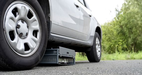 Close-up of Shark Spike under a parked SUV, in a concealed position for tactical use.