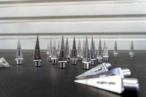 Workshop close-up showcasing the metal spikes of Shark Spike laid out on a workbench.