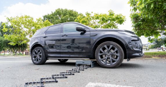 Side view of Range Rover with hidden Shark Spike deployed towards the road.