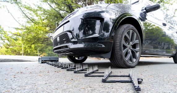 Low angle front view of Range Rover with Shark Spike deployed in front of front tires.